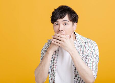 Closeup portrait of  young  man with hand over his mouth