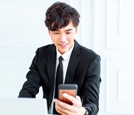 young business man watching the smart phone  in the office