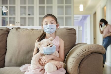 child and mother in medical masks while coronavirus quarantined at homeの写真素材