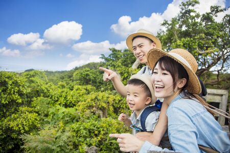 happy family hiking through the forest and  looking the viewの写真素材