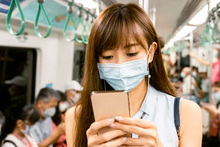 young Asian woman wearing  surgical mask in the subwayの写真素材