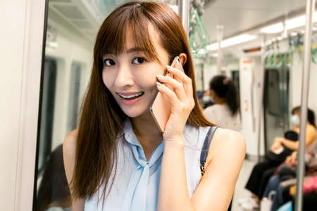 young woman talking on the phone in  subway train
