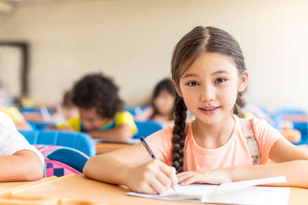 beautiful little girl studying in the classroom.の写真素材