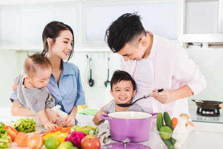 happy family tasting the soup in kitchenの写真素材