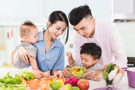 happy family eating salad in kitchenの写真素材
