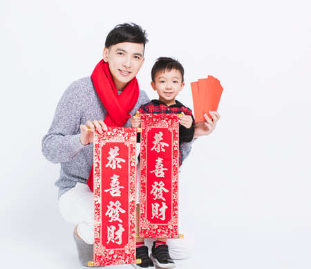 Happy asian father and son showing Red Envelopes and Celebrating new year. chinese text: Congratulations for Chinese New Yearの写真素材