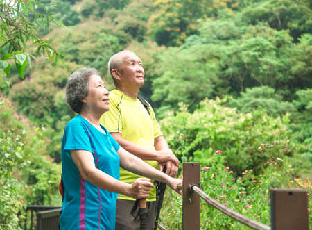Happy Asian senior couple hiking in nature parkの写真素材