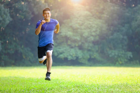 man in face mask and running in the parkの写真素材