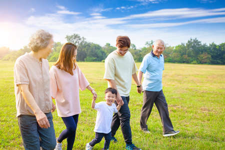 three generation asian family walking in the parkの写真素材