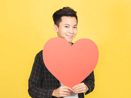 happy young man showing heart and love shape gestureの写真素材