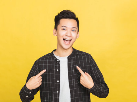 Happy young Asian man raising his fists doing yes gestureの写真素材