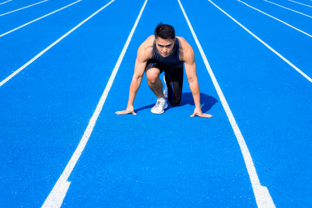 Male athlete on race track is ready to runの写真素材