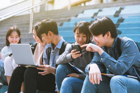 Happy Teenager Students talking and sitting On the Stairsの写真素材