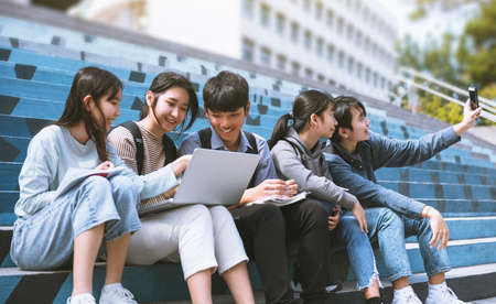 Happy Teenager Students talking and sitting On the Stairsの写真素材