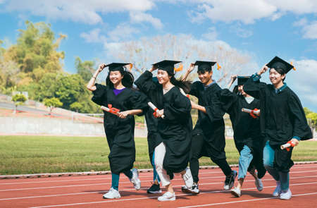 Group of Students Celebrating Graduation and running on the trackの写真素材