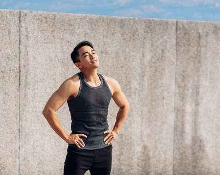Muscular Asian young man doing exercises at homeの写真素材