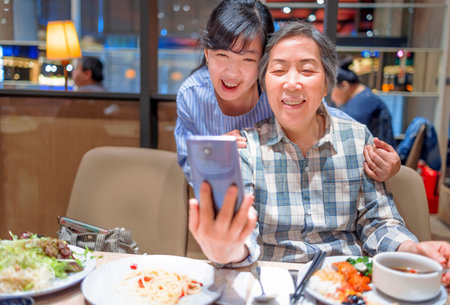 Happy mother and daughter having fun in restaurantの写真素材
