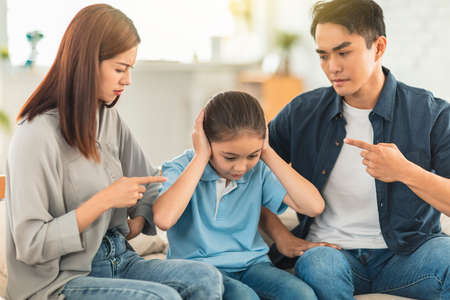 Angry parent scolding his daughter in living room at home