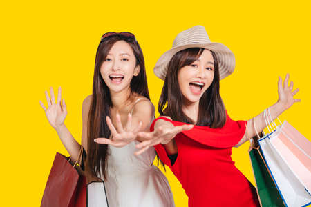 happy young women dressed in summer clothes holding shopping bags