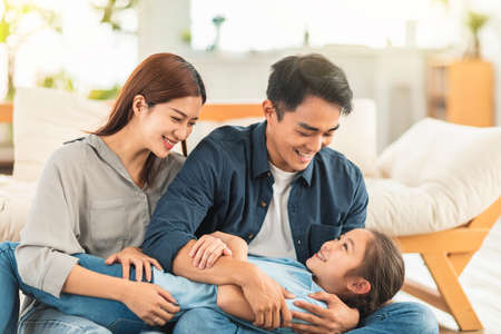 Happy family playing on the couch at homeの写真素材