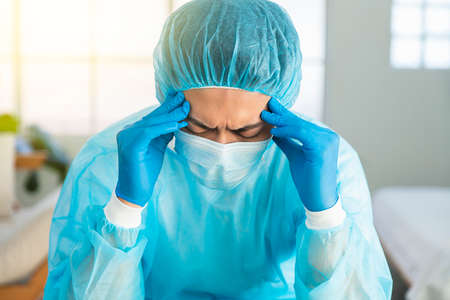 Doctor wear face mask, gloves, blue green uniform showing heart hands shape and stay home conceptsの写真素材