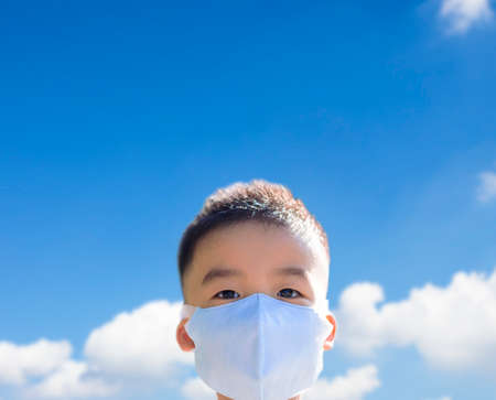 Kids wearing the mask for protect them self from viruses. cloud background.の写真素材
