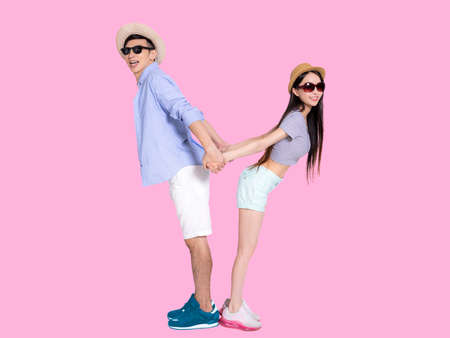 Happy Young couple in sunglasses and jumping .Isolated on blue background.
