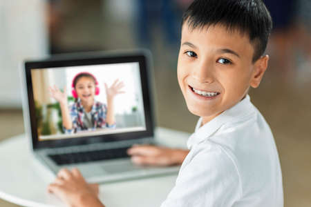 Cheerful boy using laptop.Study online.