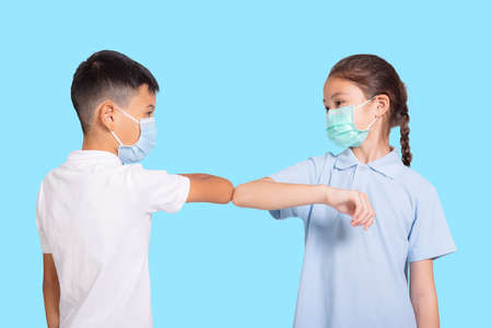 Boy and girl in medical mask. Isolated on blue background.の写真素材