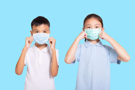 Boy and girl in medical mask. Isolated on blue background.の写真素材