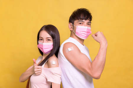 Young couple receive anti virus vaccine and showing thumbs upの写真素材