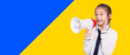 Happy student girl wearing uniform and holding with megaphoneの写真素材