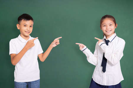 Happy student boy and girl pointing at each other.の写真素材
