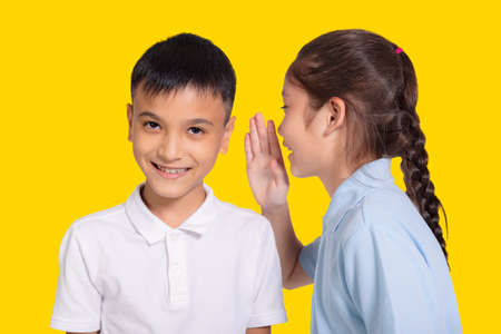 Happy student girl and boy whispers.の写真素材