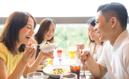 Happy Young group enjoying food and drink in restaurantの写真素材