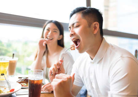 Happy couple having fun during lunch in restaurantの写真素材