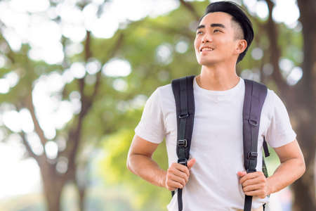 Smiling handsome young man looking aboveの写真素材