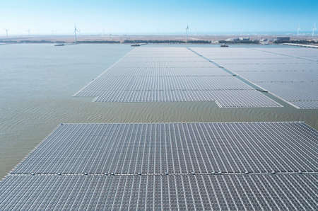 Aerial view of Floating solar power plant and wind turbine farm