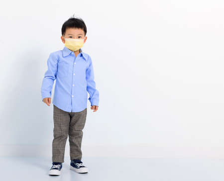 child standing over white background and wearing face maskの写真素材