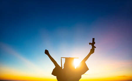 The silhouette of Student Celebrating Graduation watching the sunlightの写真素材