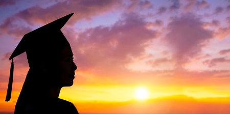 Side view Silhouette of university graduate woman in sunset skyの写真素材