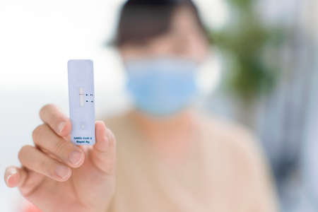 Woman showing antigen self test card with negative result for Covid-19の写真素材