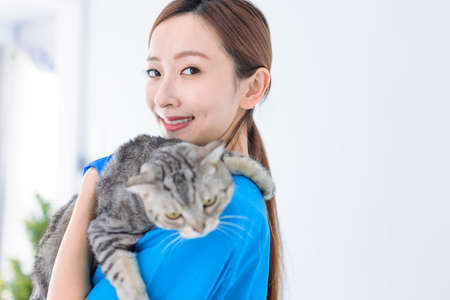 beautiful smiling woman with a cat in her arms. Veterinary medicine concept.の写真素材