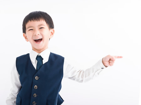 Happy boy pointing finger away at copy spaceの写真素材