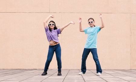 Happy girls dancing outdoors in city street and having fun togetherの写真素材