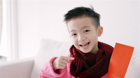 Happy Asian boy showing and holding red envelope. Happy Chinese New Year Concept.の写真素材
