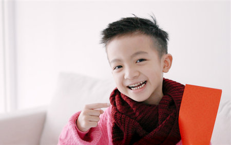 Happy Asian boy showing and holding red envelope. Happy Chinese New Year Concept.の写真素材