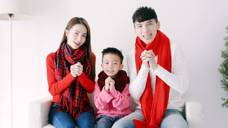 happy chinese new year. asian family showing congratulation gesture at homeの写真素材