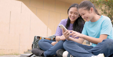 Happy Asian student girls using smart phone in schoolの写真素材