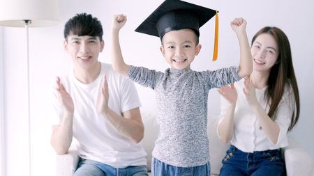 Parent congratulates child on graduating from kindergarten ,Children graduate, Parent's love, kid graduation succeed conceptの写真素材